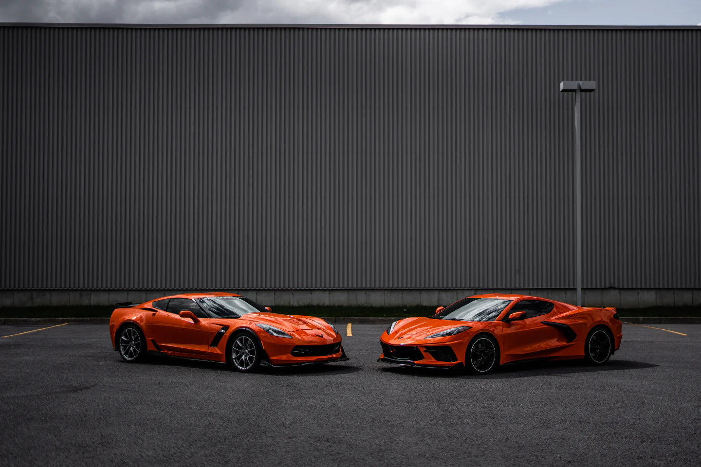 Two orange Corvettes facing each other