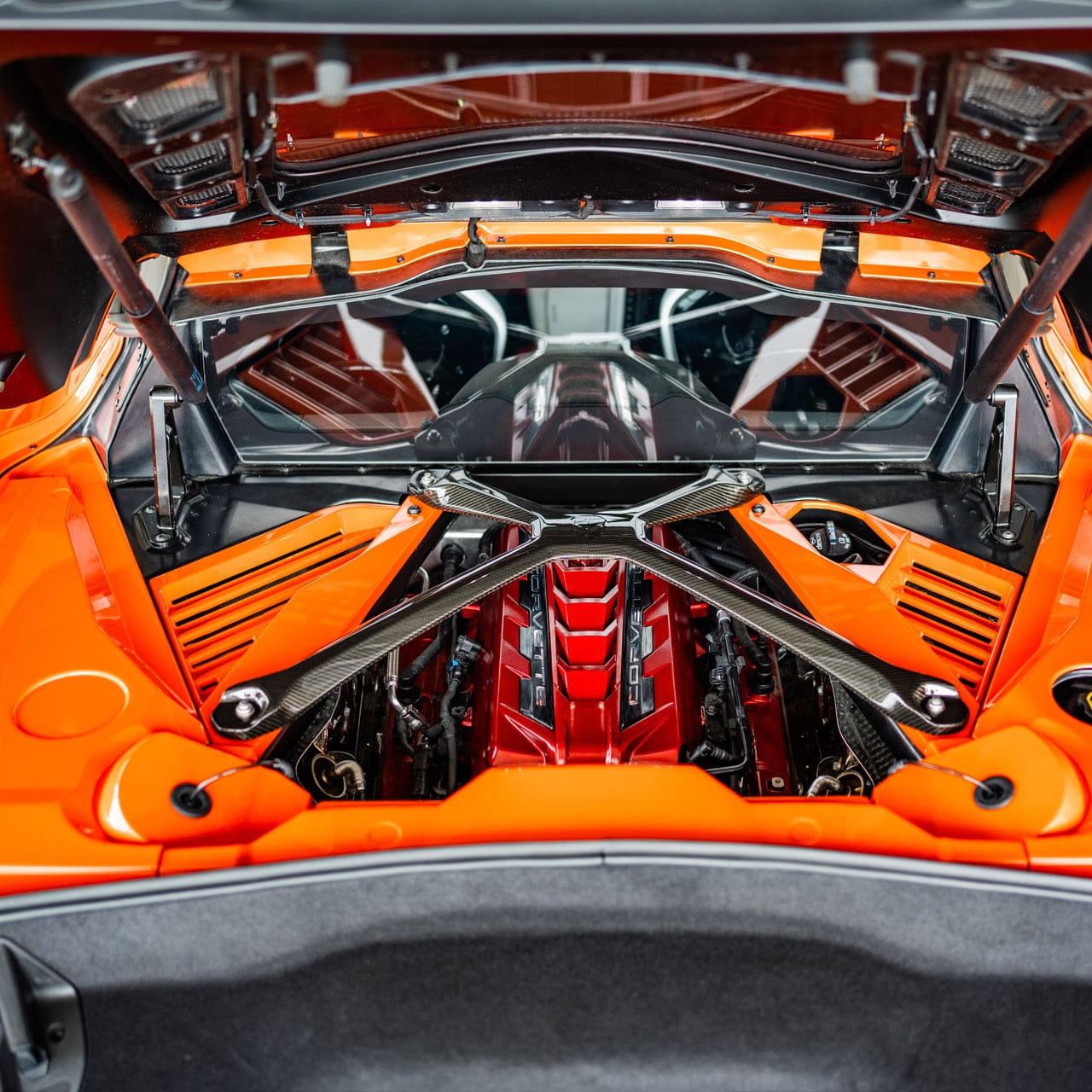 A Carbon Fiber ACS X-Brace installed alongside Sebring Orange Engine Appearance Panels